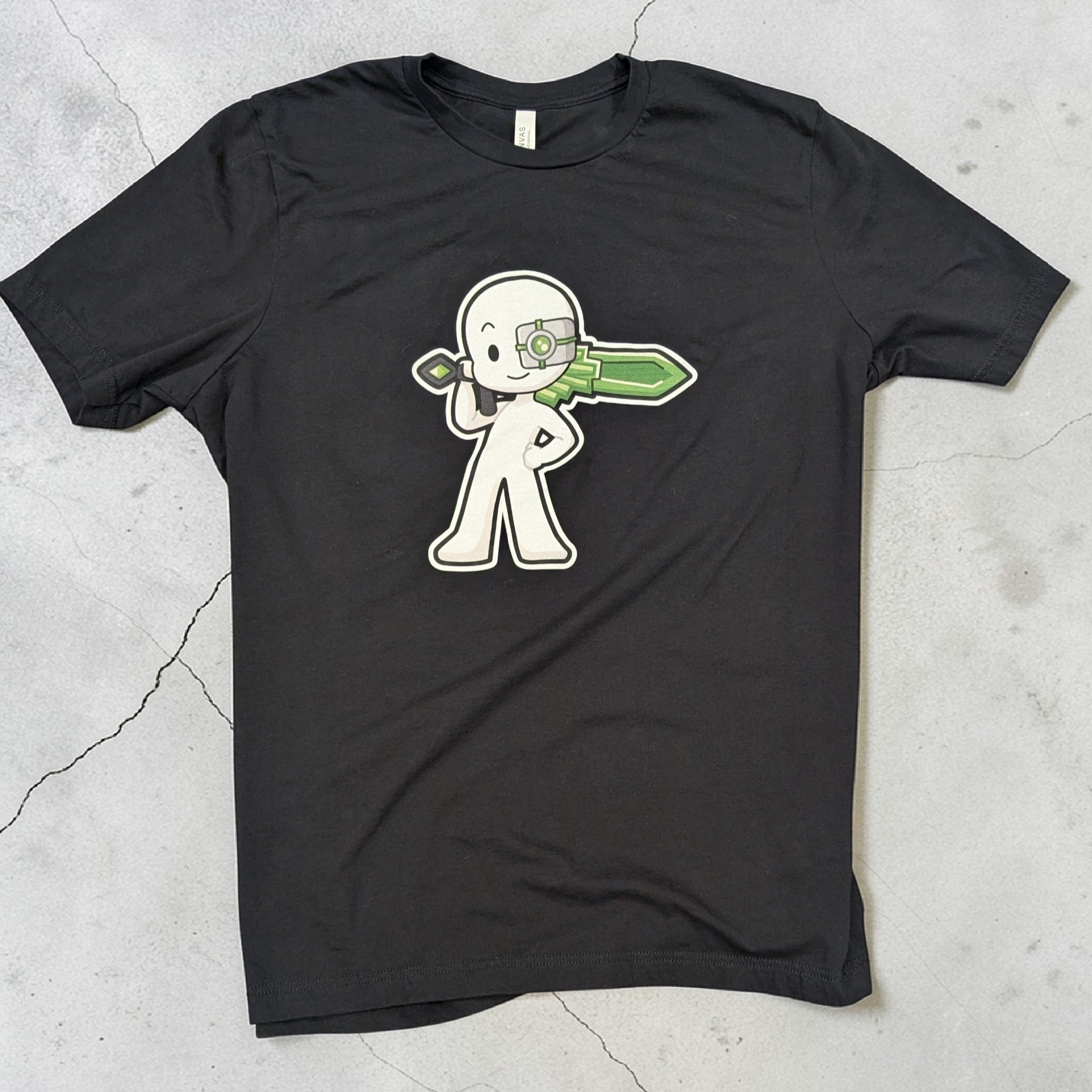 Black t-shirt with a white graphic design on a gray concrete surface